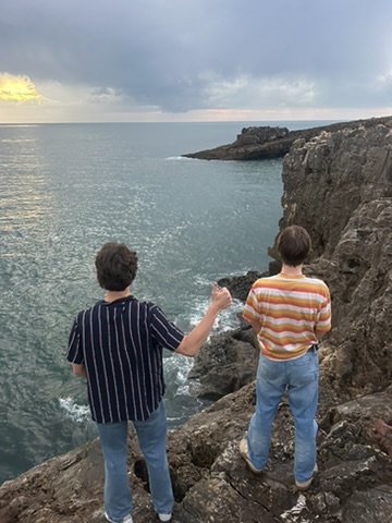 Friends standing on a seaside cliff